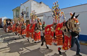 Reatas de mulas enjaezadas o vestidas con arreos o guarniciones y enganchadas a carros de época.